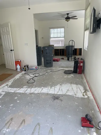 Room with the flooring removed down to the slab and drying equipment running, a typical slab-home water loss