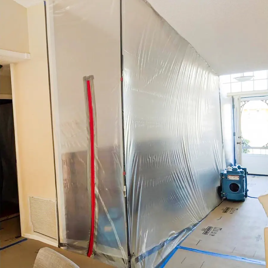 Plastic containment wall with a zipper door and an air scrubber set up for water damage restoration
