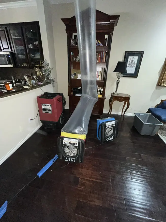 Containment duct, dehumidifier and air scrubber running in a living room during a water damage dry-out