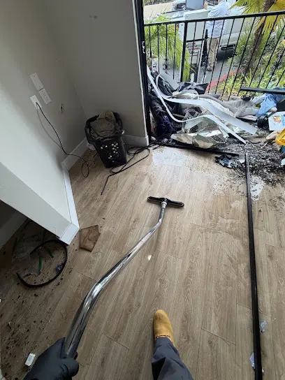 Extraction wand pulling water off a soaked floor by a balcony door during emergency water extraction in Encinitas, CA