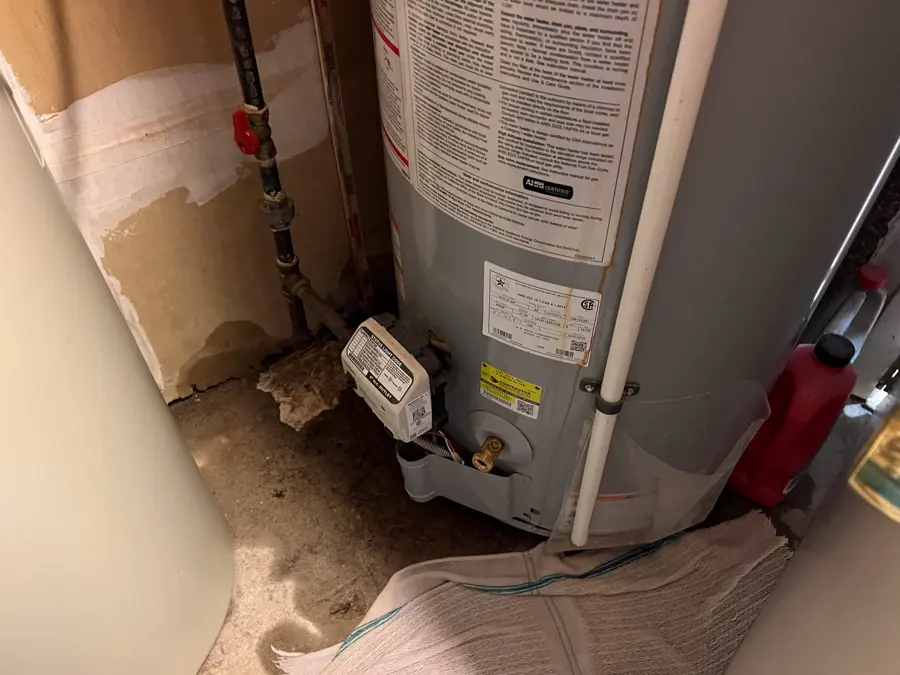 Water heater in a closet with a water-stained floor around its base, water heater leak cleanup in Encinitas, CA